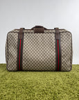 Valigia vintage Gucci realizzata in tela GG monogramma con dettagli in pelle marrone e strisce Web