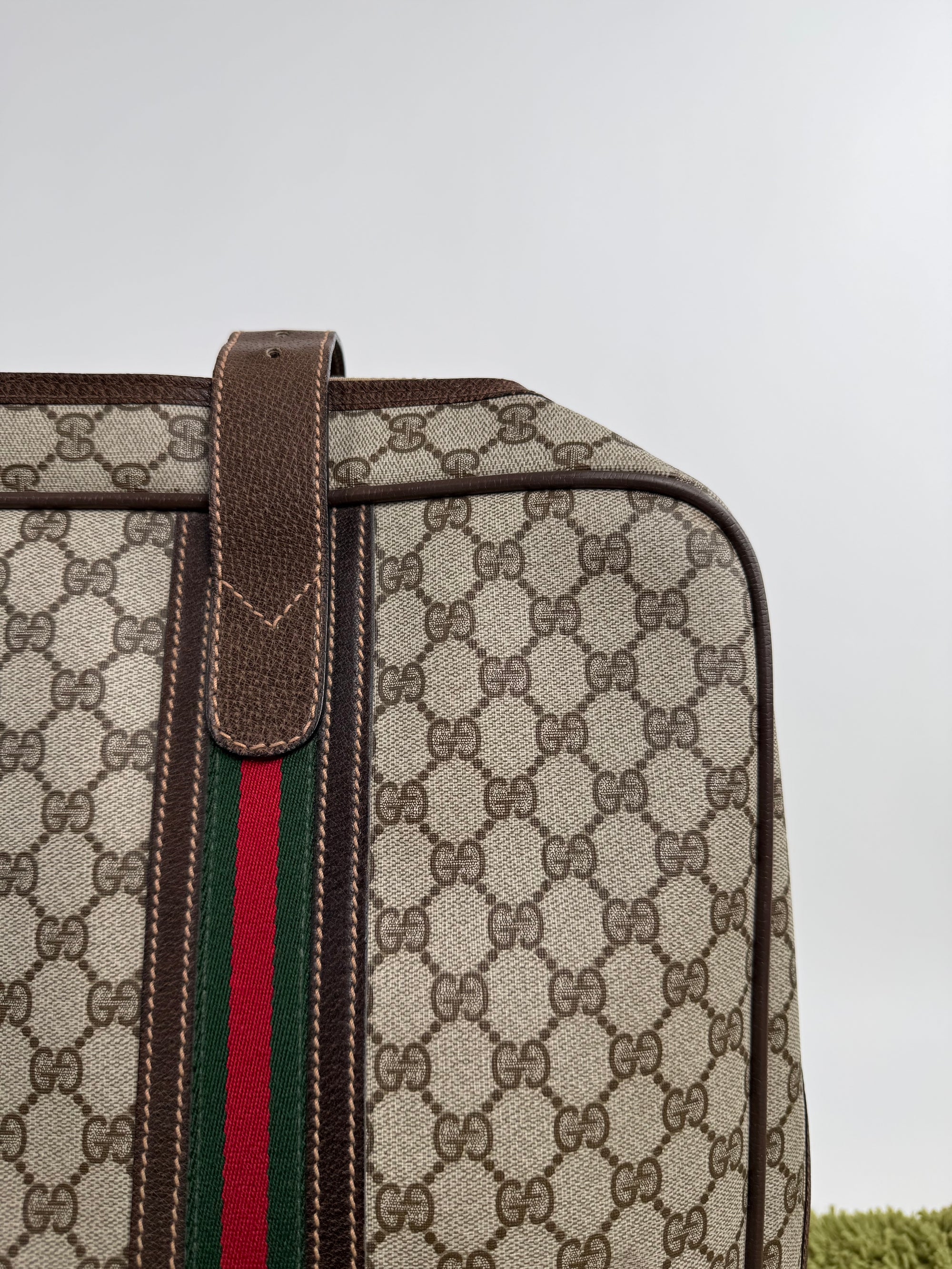 Valigia vintage Gucci realizzata in tela GG monogramma con dettagli in pelle marrone e strisce Web