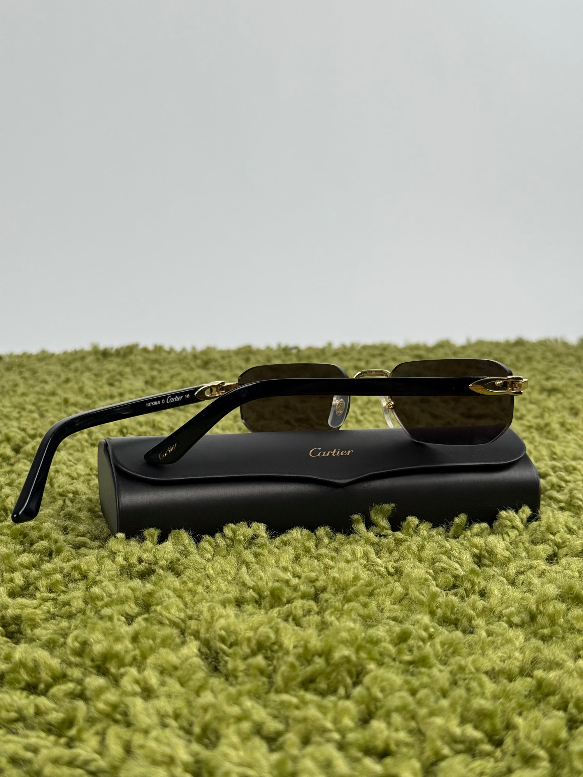 Occhiali da sole Cartier CT0622S con aste in acetato nero con un dettaglio dorato a forma di C