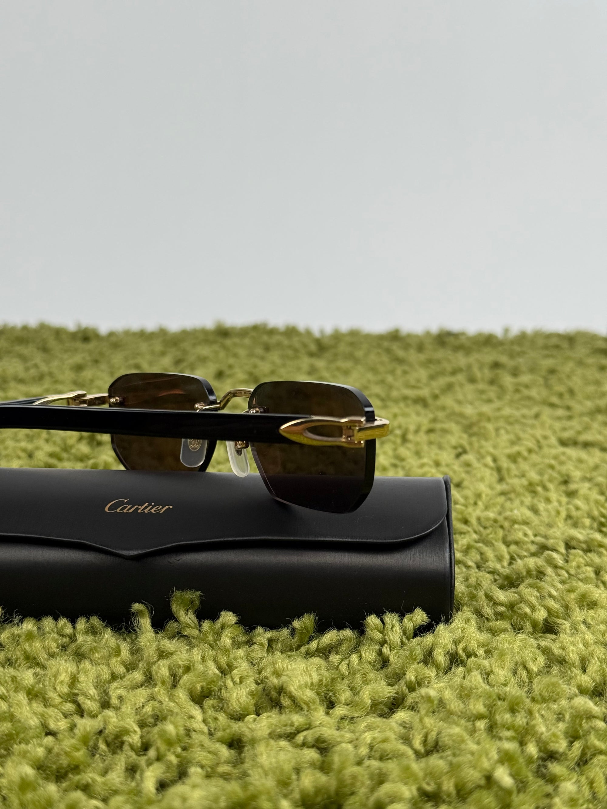 Occhiali da sole Cartier CT0622S con aste in acetato nero con un dettaglio dorato a forma di C