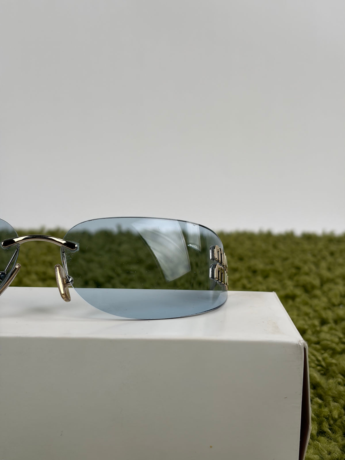 Occhiali da sole Miu Miu MU in oro pallido con lenti azzurre